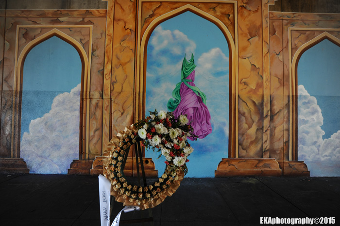 A wreath for slain muralist Antonio Ramos hangs in front of the mural site